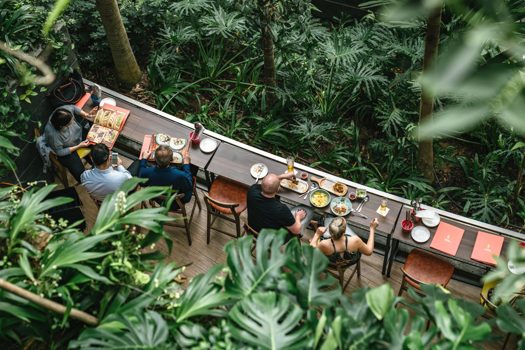 A photo of people enjoying the surroundings of a biophilic restaurant at Change airport.