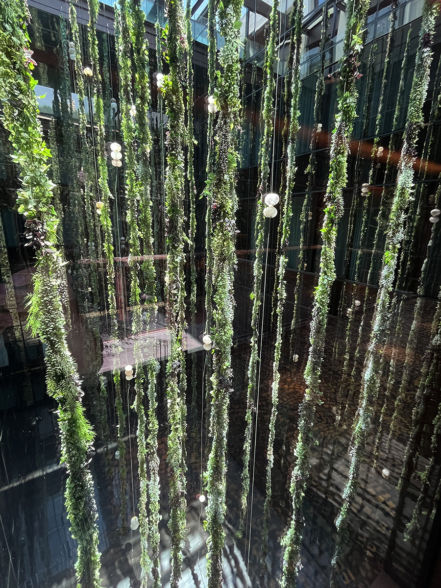 The biophilic courtyard in Thompson Madrid is filled with hanging synthetic plants.